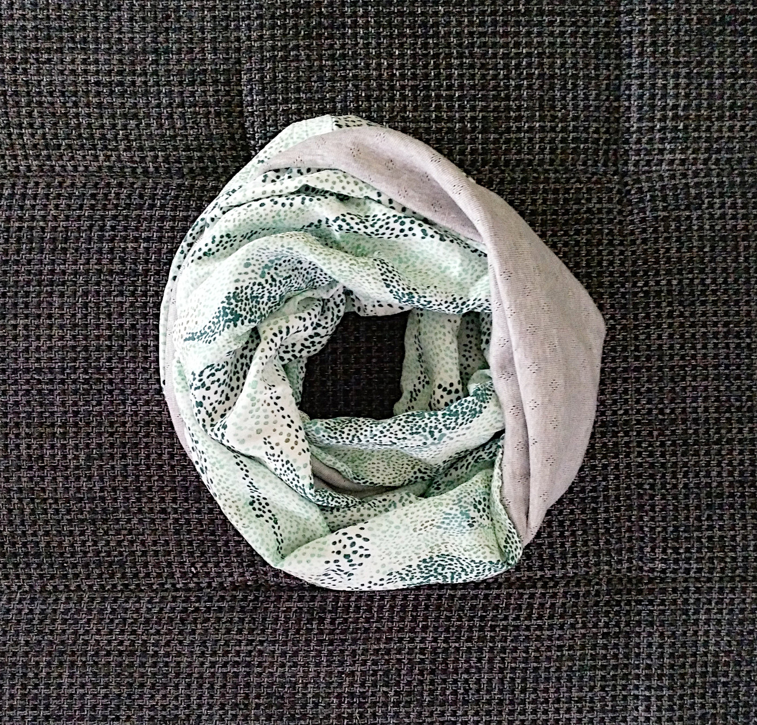 Loop Schal aus einem grauen und einem grün gepunkteten Stoff